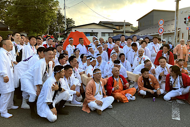 記念撮影する火祭りの神輿担ぎ手